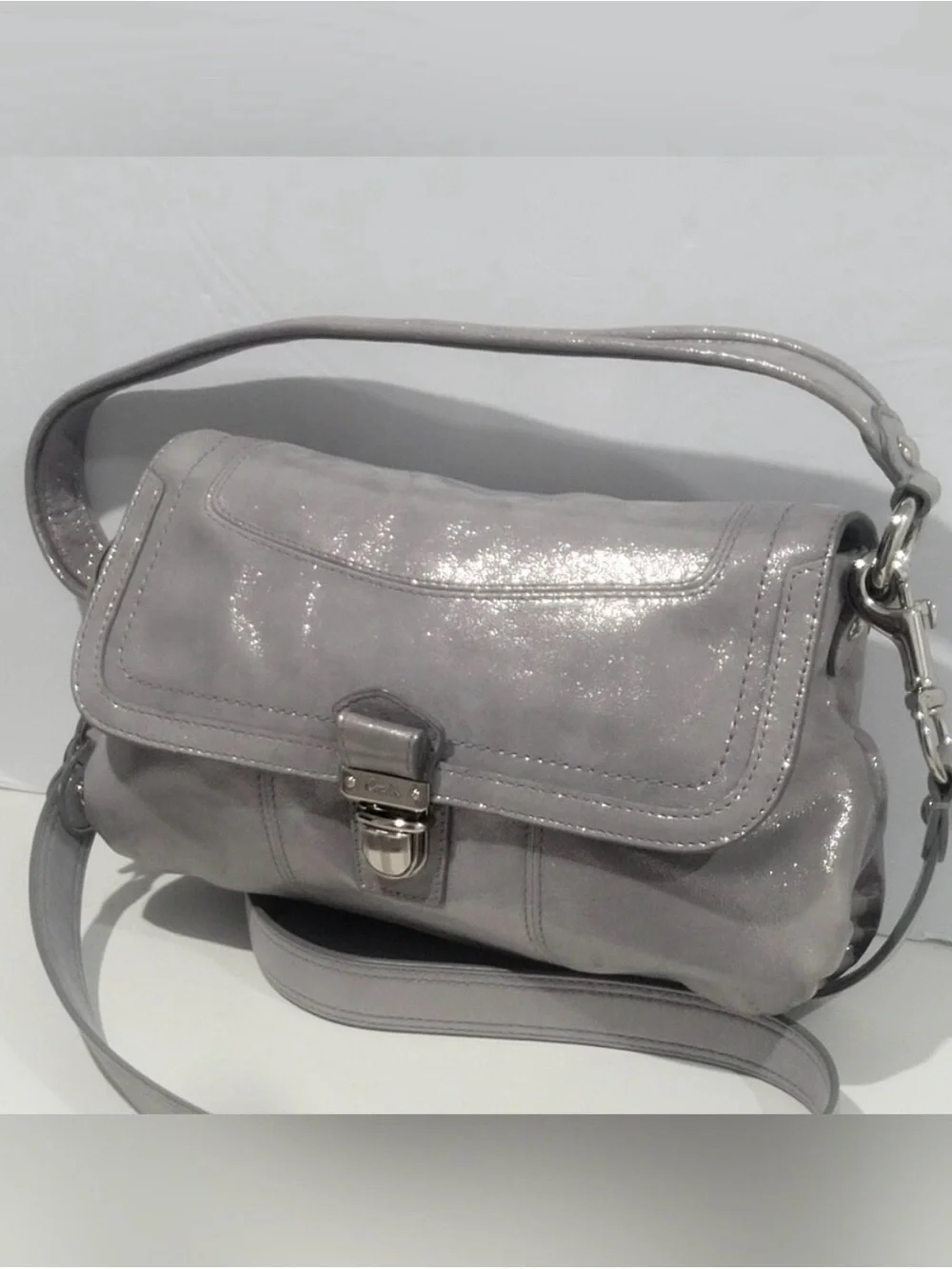 Coach Poppy Layla shimmery leather shoulder bag with a push-lock closure.